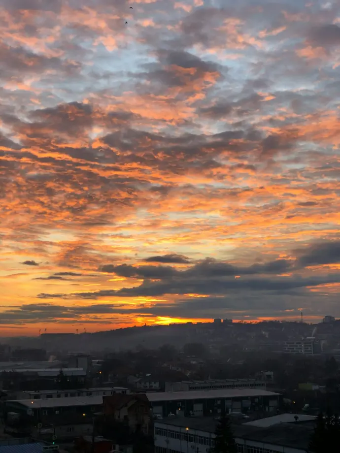silhouette of buildings under cloudy sky during sunset